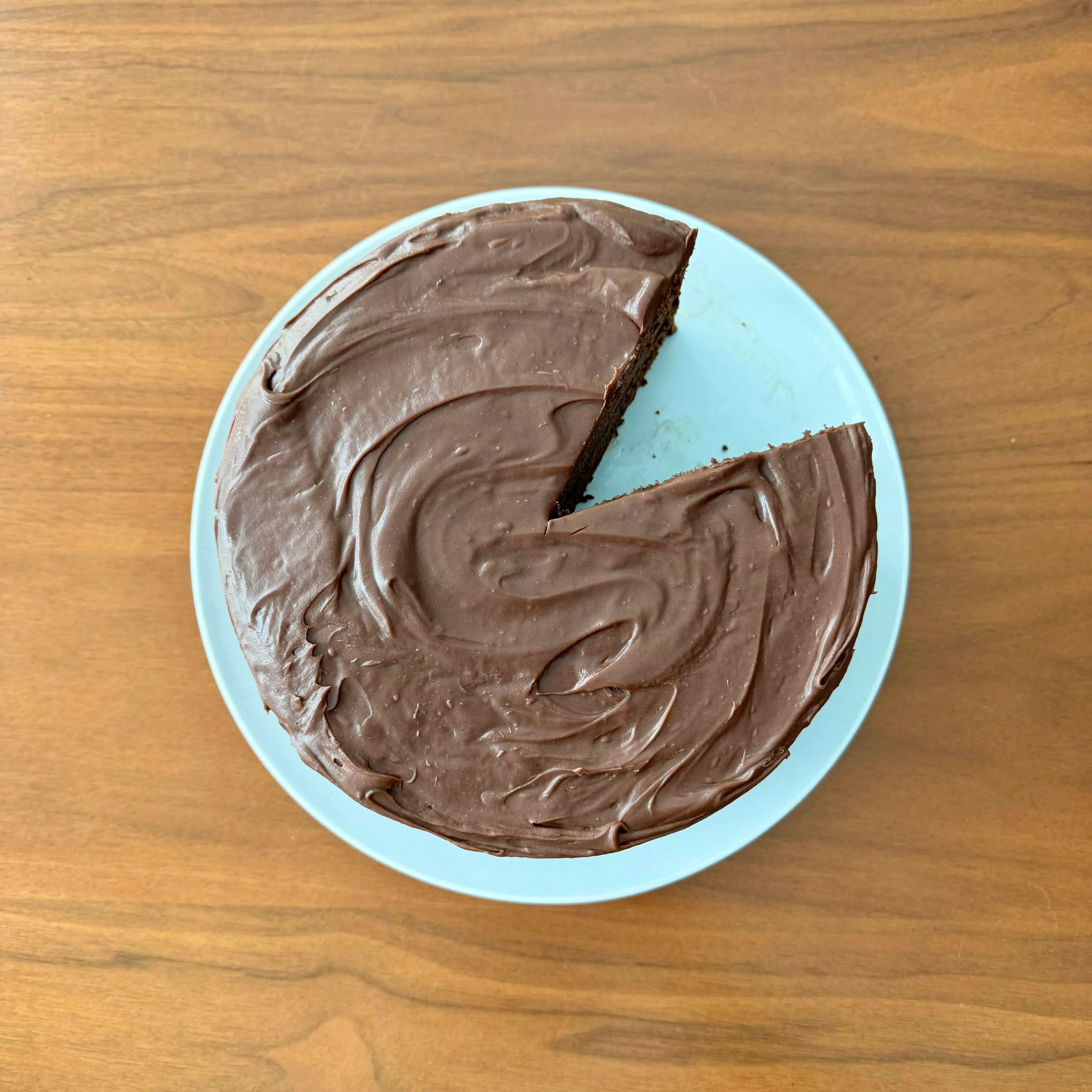 Top-down view of the same cake showing swirled chocolate frosting on a pale blue platter.